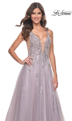 A woman smiles while wearing the Sequined Long Mauve Prom Dress: La Femme 31995, featuring a sleeveless design, deep V-neckline, and silver sequin details. The "La Femme" logo appears in the top right corner.