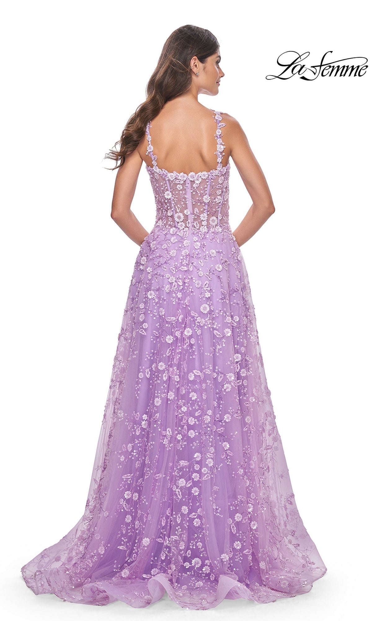 A woman is seen from the back in the La Femme Floral-Embellished Long Prom Dress 31996, a lavender gown with thin straps, sheer detailing, and elegant floral appliqué—perfect for a stunning evening look.
