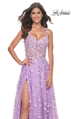 A woman poses and smiles in front of a white background wearing the La Femme Floral-Embellished Long Prom Dress 31996, featuring a lavender hue, floral details, sheer skirt, and thigh-high slit. The "La Femme" logo appears in the top right corner.