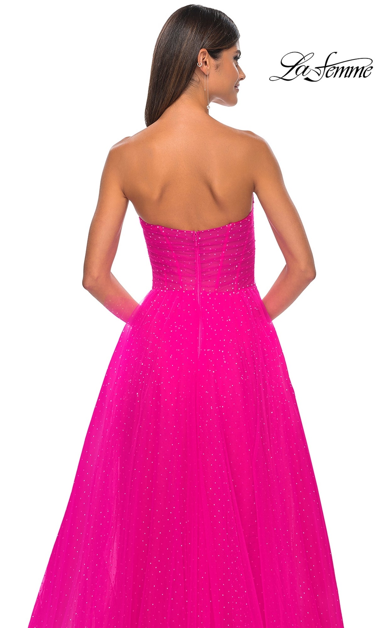 A woman is shown from the back wearing the La Femme Strapless Long Prom Ball Gown 31997 in bright pink, featuring a tulle overlay and subtle glitter accents.
