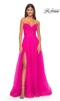 A woman models the La Femme Strapless Long Prom Ball Gown 31997 in bright pink with a sweetheart neckline, high slit, and subtle embellishments, standing before a white background with the "La Femme" logo.