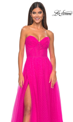 A woman wearing the La Femme Strapless Long Prom Ball Gown 31997 in bright pink, featuring a sweetheart neckline, subtle pleated bodice, high slit, and small sparkling accents.