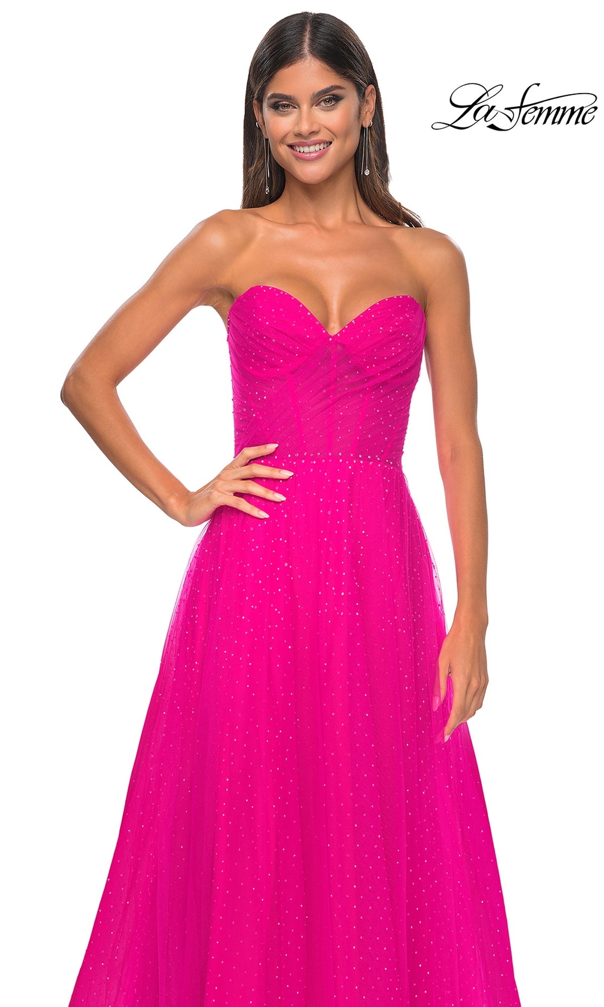 A woman wears the La Femme Strapless Long Prom Ball Gown 31997 in bright pink, featuring a fitted bodice and glittery tulle skirt. The La Femme logo appears in the top right corner.