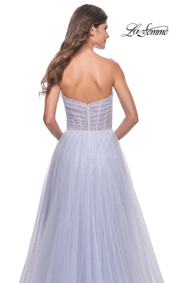 A woman models the La Femme Strapless Long Prom Ball Gown 31997 in light lavender, featuring a fitted bodice and flowing tulle A-line skirt, elegantly shown from the back.