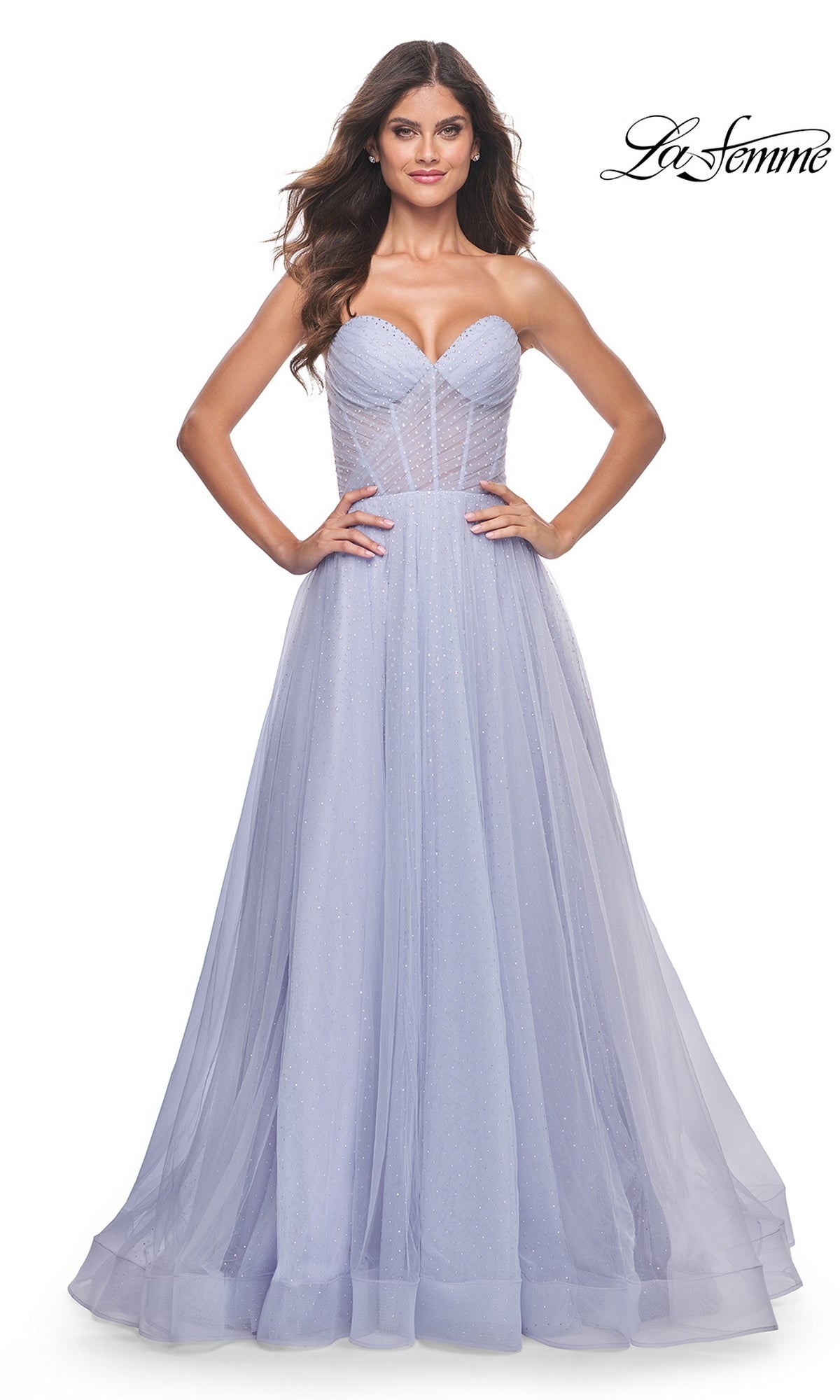 A woman models the La Femme Strapless Long Prom Ball Gown 31997 in lavender, featuring a corset-style bodice and flowing tulle skirt. The 