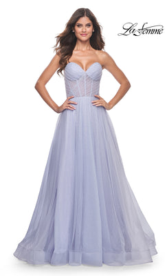A woman models the La Femme Strapless Long Prom Ball Gown 31997 in lavender, featuring a corset-style bodice and flowing tulle skirt. The "La Femme" logo is visible in the top right corner.