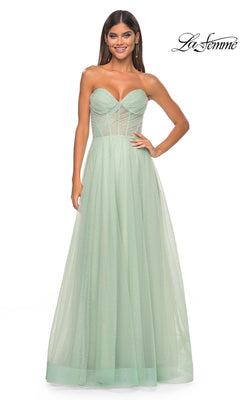 A woman wears the La Femme Strapless Long Prom Ball Gown 31997 in mint green, featuring a fitted bodice with sheer details, glittery texture, and a floor-length A-line silhouette for an elegant prom look.