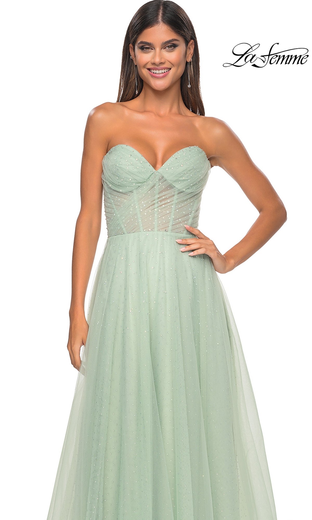 A woman stands against a white background wearing the La Femme Strapless Long Prom Ball Gown 31997 in mint green, featuring a fitted sheer bodice and a flowing A-line skirt.