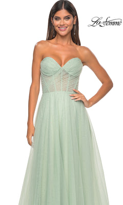 A woman stands against a white background wearing the La Femme Strapless Long Prom Ball Gown 31997 in mint green, featuring a fitted sheer bodice and a flowing A-line skirt.