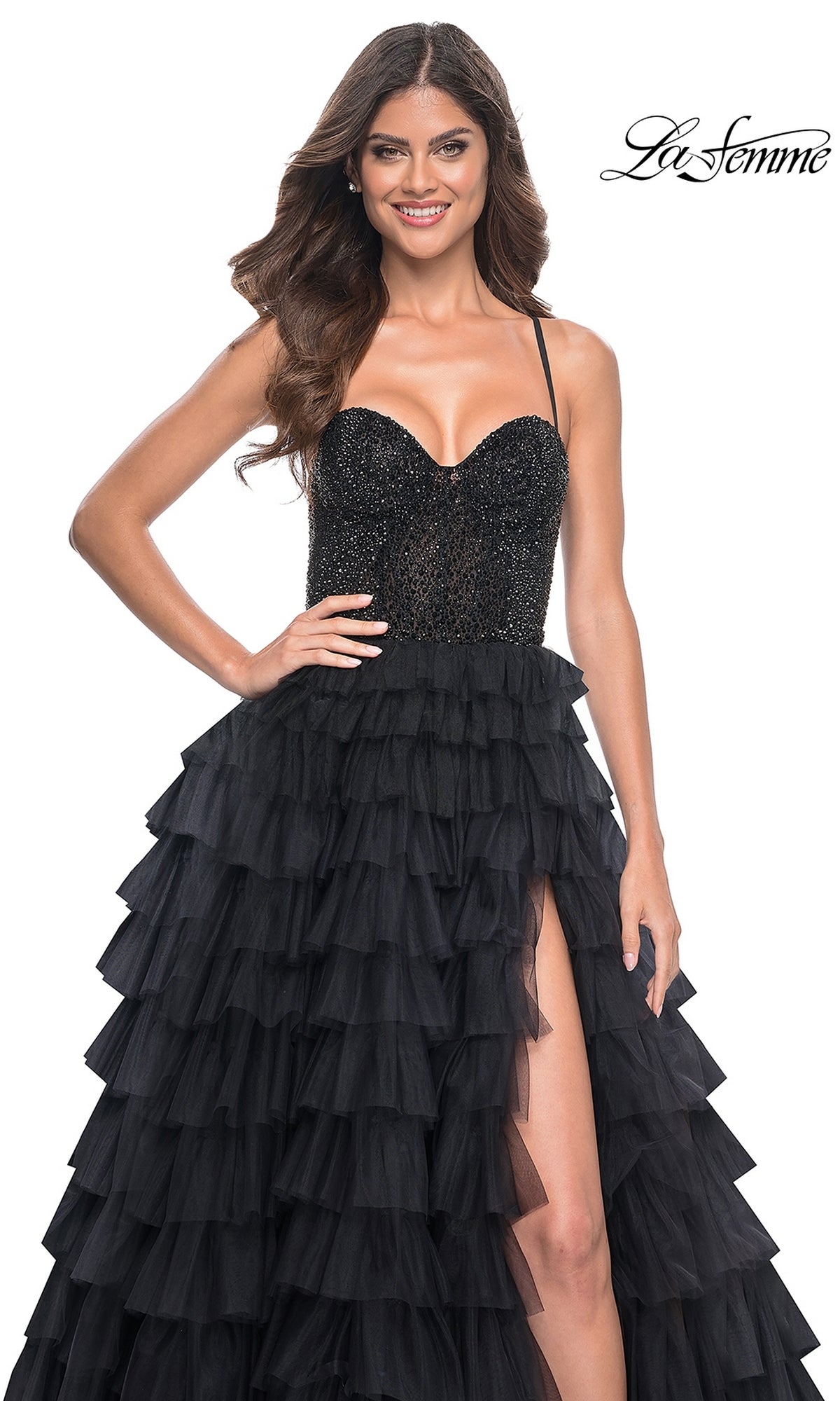 Smiling woman wearing the La Femme Long Ruffled Prom Ball Gown 32002 with beaded bodice, A-line silhouette, thigh-high slit, and black ruffles, standing against a white background.