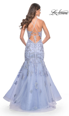 A woman models the La Femme Long Lace Mermaid Prom Dress 32004, featuring lavender lace applique, a tulle mermaid skirt, and a crisscross open back. The "La Femme" logo is displayed in the top right corner.