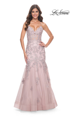 A woman stands smiling with hands on hips, wearing the La Femme Long Lace Mermaid Prom Dress 32004 in pale pink, featuring lace appliqué details and thin straps. The "La Femme" logo appears in the top right corner.