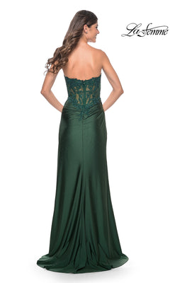 A woman faces away, wearing the La Femme Sheer-Waist Strapless Long Prom Dress 32011 in dark green with a lace-detailed back. The La Femme logo is displayed in the top right corner.