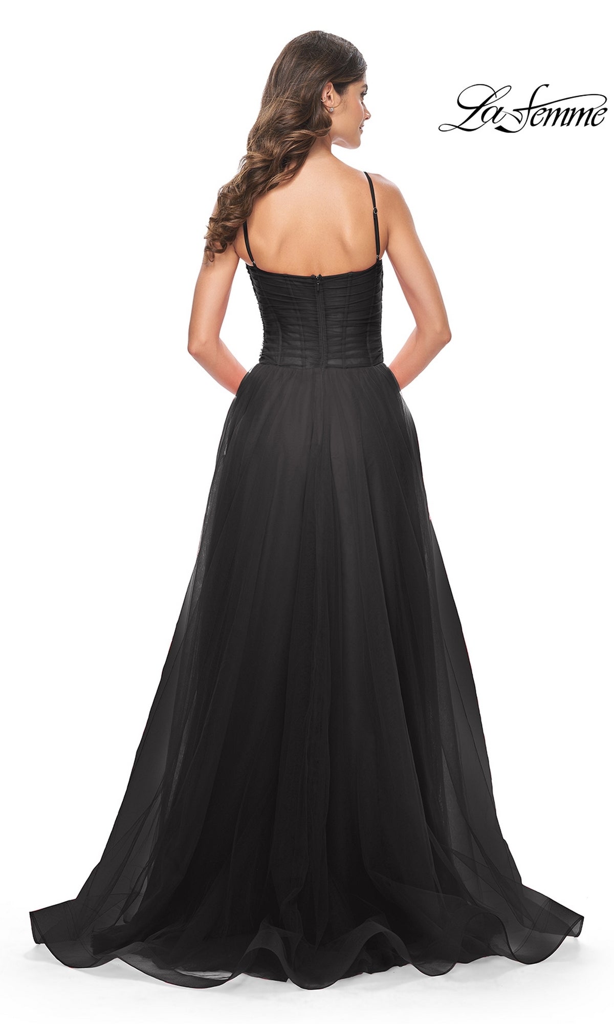 A woman is seen from the back wearing the La Femme Sheer-Waist Long Prom Ball Gown 32017, a black strapless dress with a fitted bodice, flowing A-line skirt, and subtle train. The La Femme logo appears in the corner.