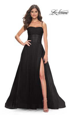 A woman models the La Femme Sheer-Waist Long Prom Ball Gown 32017, featuring spaghetti straps, a sheer corset bodice, and a high slit. She stands against a white background with the "La Femme" logo in the top right corner.