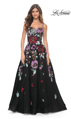 Woman wearing the La Femme Sequin-Floral Long Prom Dress 32019, featuring a long black A-line silhouette, colorful sequin floral embroidery, thin straps, and a fitted bodice. "La Femme" logo appears in the top right corner.