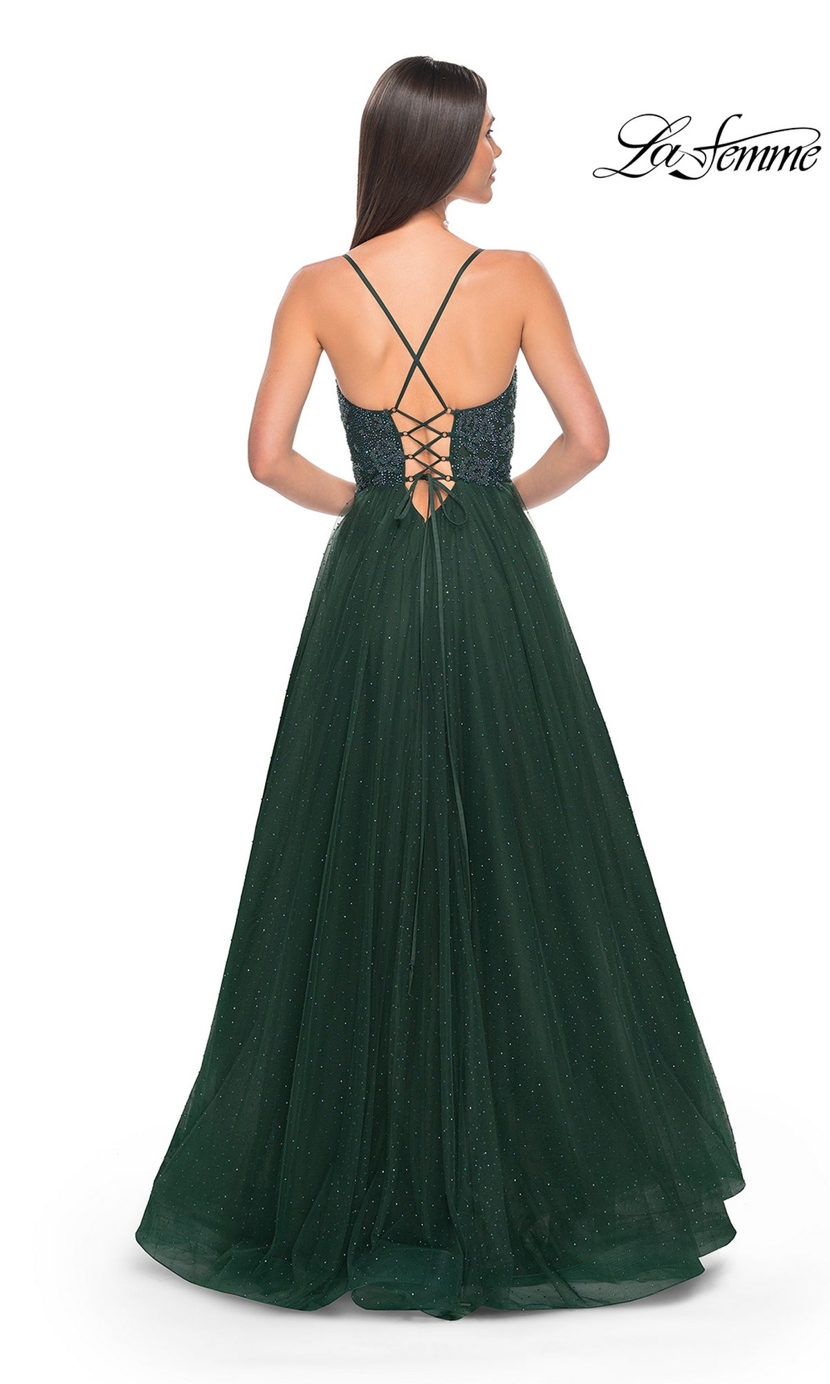 Woman in a dark green La Femme Beaded Long A-Line Prom Dress 32020 with spaghetti straps, lace-up back, subtle shimmer, and a flowing skirt, shown from behind.