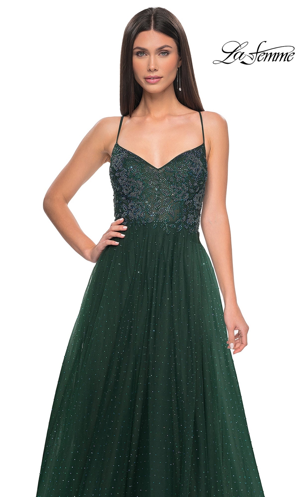 Woman wearing the La Femme Beaded Long A-Line Prom Dress 32020 in dark green, featuring thin straps, sleeveless design, beaded fitted bodice, and a flowing skirt. 