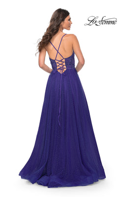A woman stands with her back to the camera in the La Femme Beaded Long A-Line Prom Dress 32020, a floor-length gown in deep purple with a sparkly finish and crisscross lace-up back detail.