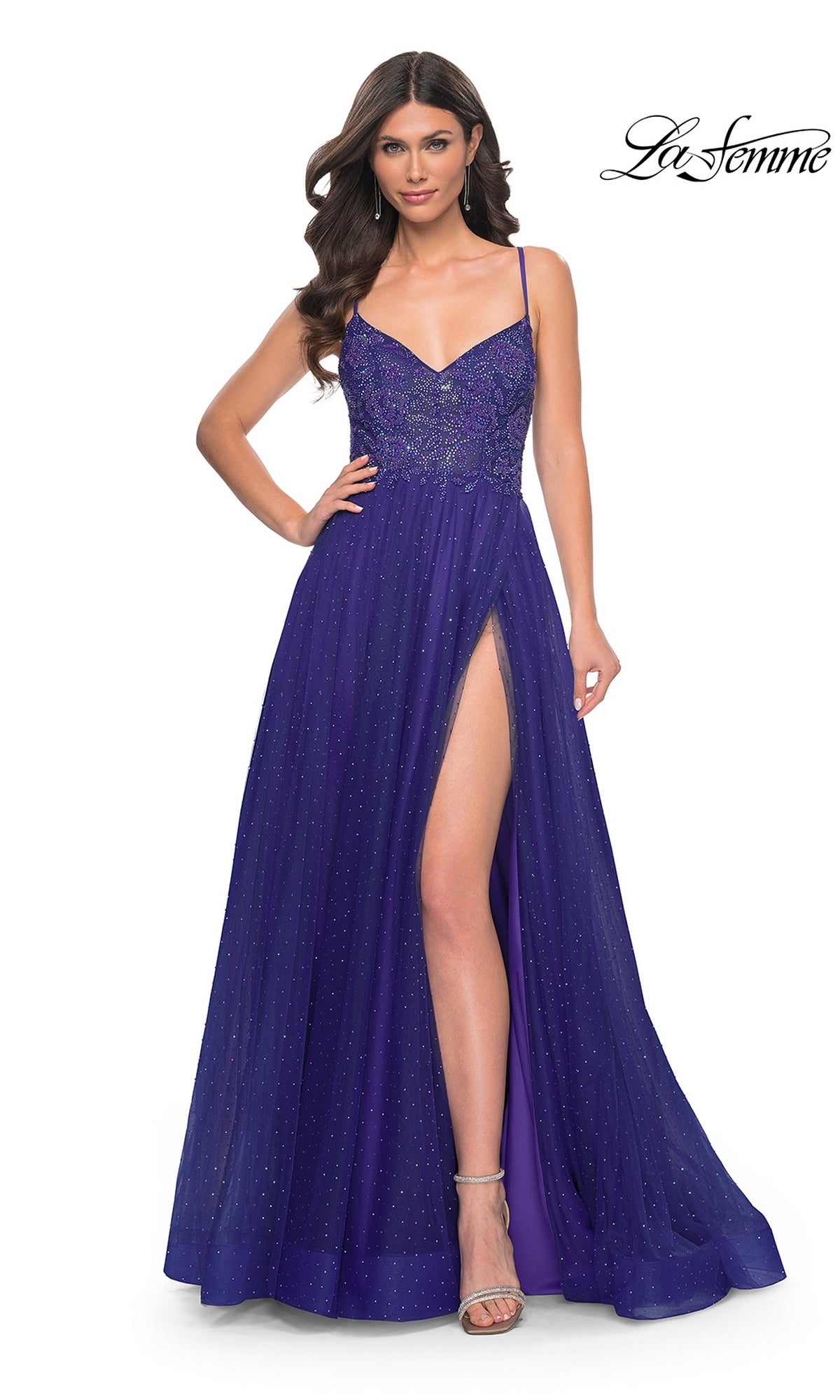 A woman wears the La Femme Beaded Long A-Line Prom Dress 32020, a floor-length deep purple gown with thin straps, a thigh-high slit, beaded bodice, and subtle shimmer. The La Femme logo appears in the top right corner.