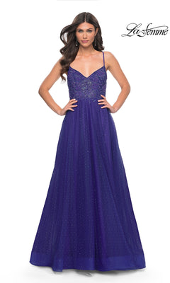 A woman wearing the La Femme Beaded Long A-Line Prom Dress 32020, a sleeveless, floor-length royal blue gown with thin straps and a sparkling bodice, stands with hands on hips. The "La Femme" logo appears in the top right corner.