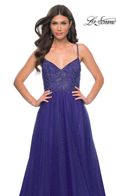 A woman models the La Femme Beaded Long A-Line Prom Dress 32020, a sleeveless purple floor-length gown with beading, posing against a white background. The "La Femme" logo appears in the top right corner.