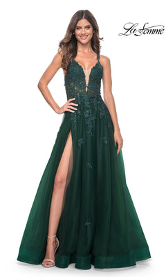 Woman wearing the La Femme Embroidered-Lace Long Prom Gown 32022 in dark green, featuring a floor-length skirt, embroidered lace bodice, thin straps, and a high slit, standing against a white background.