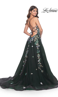A woman stands looking over her shoulder in the La Femme Sequin Flower-Print Long Prom Dress 32023, a floor-length dark green gown with sequin floral embroidery and an open crisscross back.