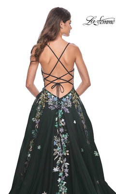 Woman in a black La Femme Sequin Flower-Print Long Prom Dress 32023 with crisscross back straps and sequin flower embroidery, standing with her back to the camera.