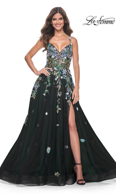 A woman stands smiling in the La Femme Sequin Flower-Print Long Prom Dress 32023, featuring black fabric, sequin floral embroidery, spaghetti straps, a deep neckline, and a thigh-high slit. La Femme logo appears in the corner.