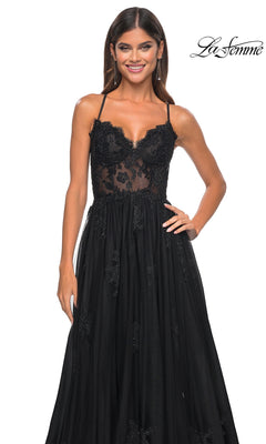 A woman stands smiling against a white background, wearing the La Femme Sheer-Corset Long A-Line Prom Dress 32028—sleeveless with black embroidered lace, a sheer bodice, and floral detailing. "La Femme" logo appears in the top right corner.