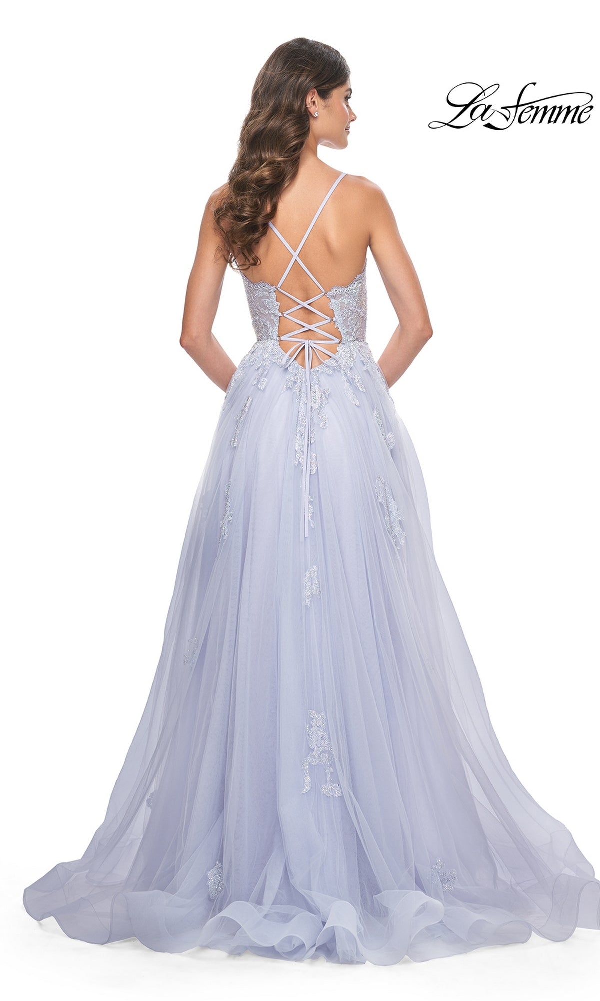 Woman in the La Femme Sheer-Corset Long A-Line Prom Dress 32028, featuring light lavender embroidered lace, an open back with crisscross straps, and a flowing tulle skirt for added elegance.