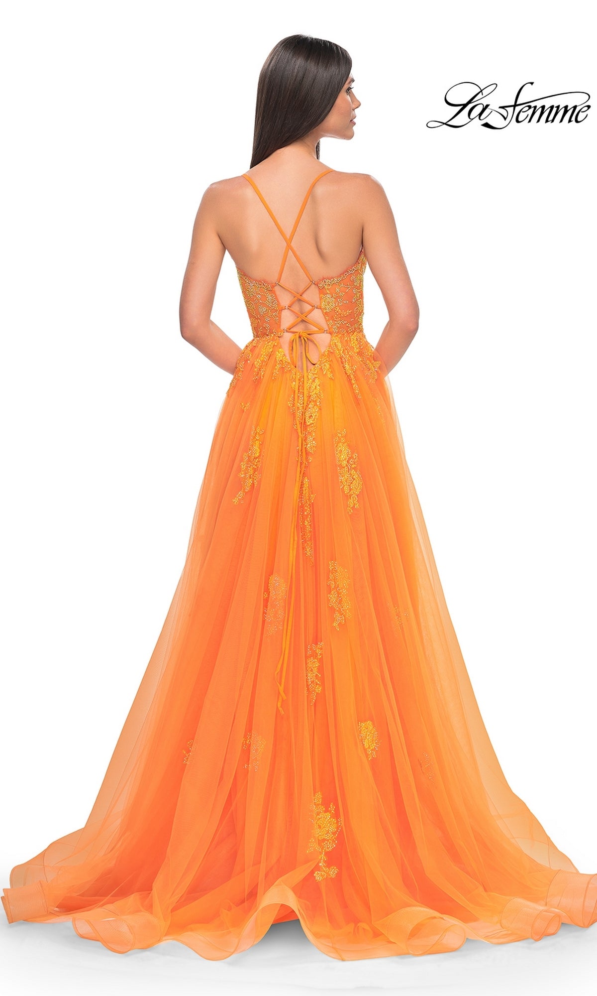 Woman faces away from the camera, wearing the La Femme Sheer-Corset Long A-Line Prom Dress 32028 in orange, featuring floor-length embroidered lace, thin crisscross straps, a lace-up back, and elegant floral details.