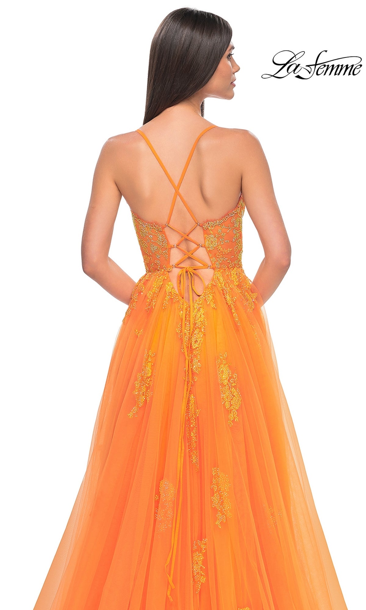 Woman in the La Femme Sheer-Corset Long A-Line Prom Dress 32028, featuring orange floral embroidered lace and a lace-up back, stands with her back to the camera against a white background.