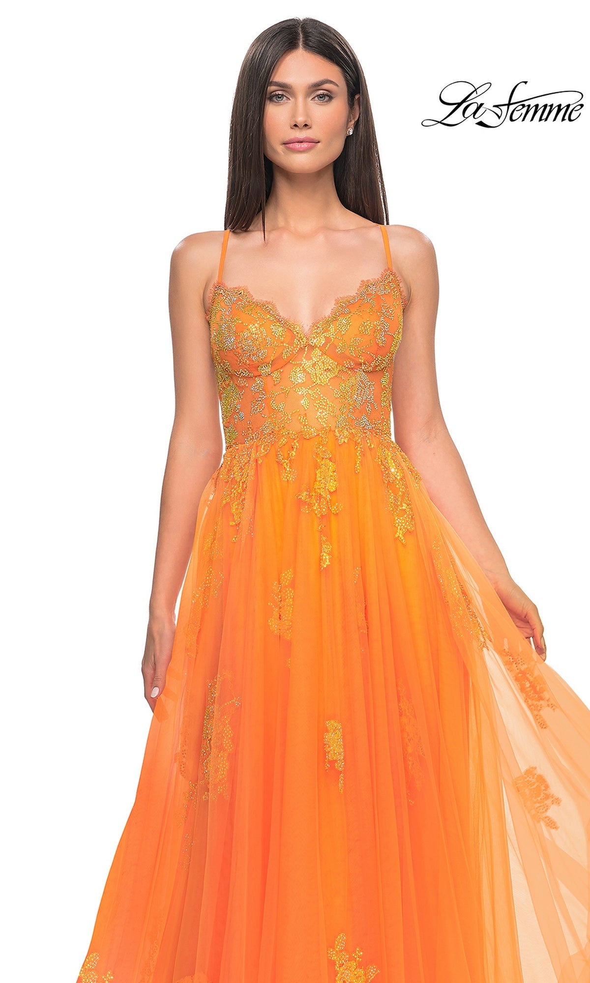 A woman wears the La Femme Sheer-Corset Long A-Line Prom Dress 32028—an orange formal gown with gold floral embroidery, sheer bodice, open back, and flowing tulle skirt. The La Femme logo is displayed in the top right corner.
