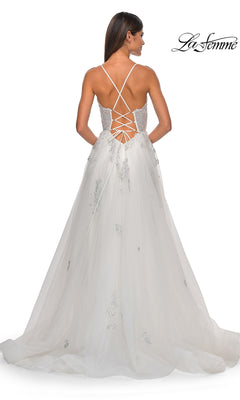 A woman faces away in the La Femme Sheer-Corset Long A-Line Prom Dress 32028, a white gown with thin crisscross straps, lace-up open back, long embellished tulle skirt, and elegant sheer corset detail.