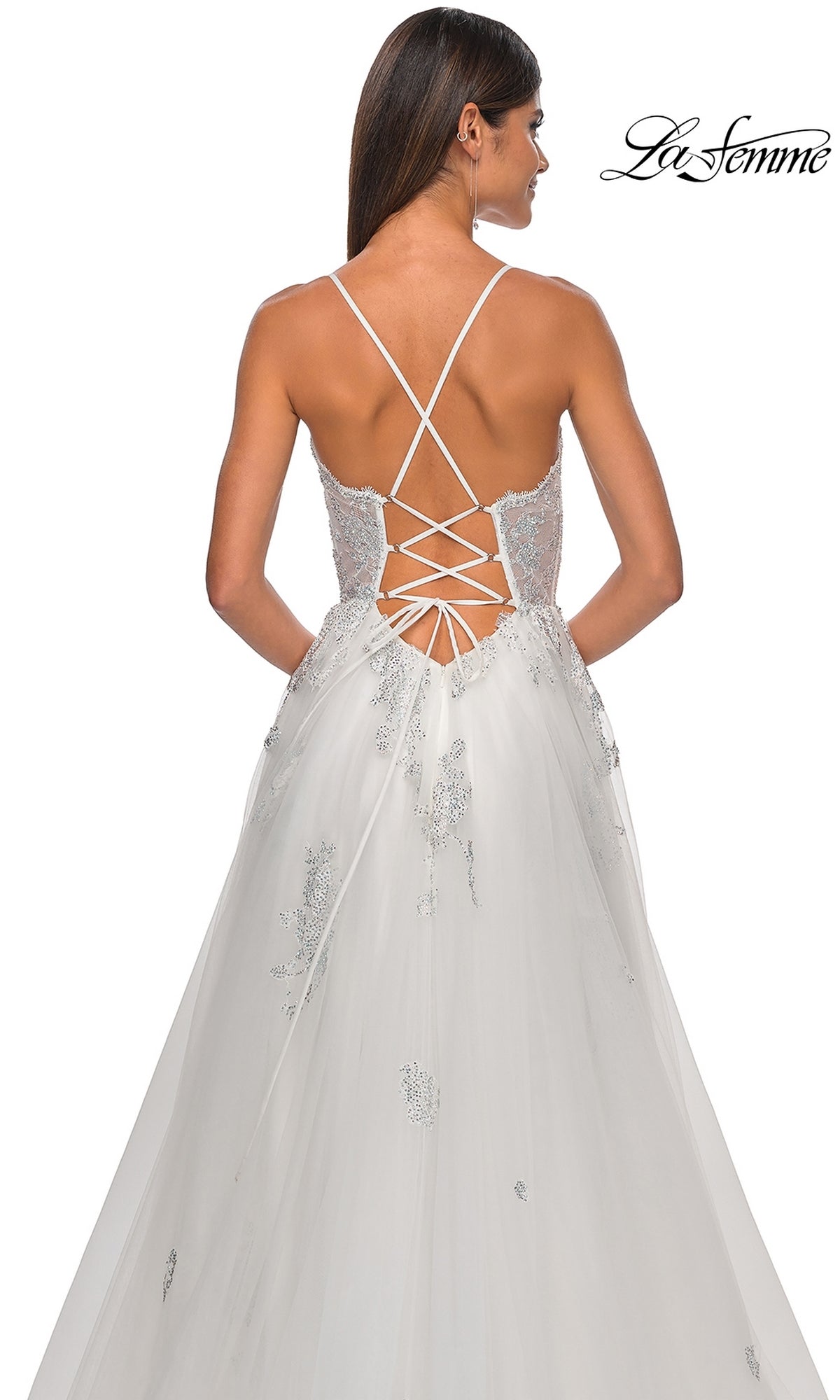 A woman wears the La Femme Sheer-Corset Long A-Line Prom Dress 32028, featuring embroidered lace, a sleeveless design, lace-up open back with crisscross straps, floral detailing, and a tulle skirt for an elegant look.
