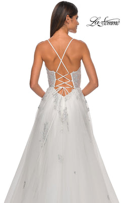 A woman wears the La Femme Sheer-Corset Long A-Line Prom Dress 32028, featuring embroidered lace, a sleeveless design, lace-up open back with crisscross straps, floral detailing, and a tulle skirt for an elegant look.