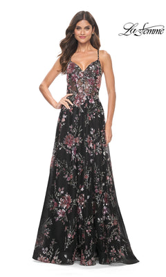 A woman stands facing forward against a white background, wearing the La Femme Floral-Sequin Long A-Line Prom Dress 32031, which is sleeveless, black, and features pink and purple floral patterns. The "La Femme" logo appears in the top right corner.