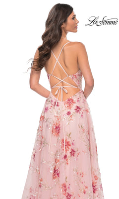 A woman wears the La Femme Floral-Sequin Long A-Line Prom Dress 32031, featuring pink floral sequins, an open back, and crisscross lace-up straps, posed against a white background.