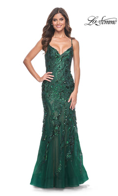 A woman wearing the Le Femme Sequin-Lace Long Mermaid Prom Dress 32049 in emerald green with thin straps and sparkling sequins stands smiling. The La Femme logo appears in the top right corner.