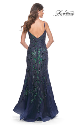 Woman in the Le Femme Sequin-Lace Long Mermaid Prom Dress 32049, featuring navy and green sequin-lace, thin straps, and a low back, stands facing away from the camera.