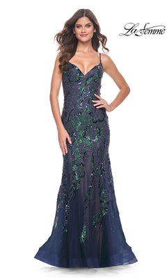 A woman models the Le Femme Sequin-Lace Long Mermaid Prom Dress 32049, featuring a navy blue floor-length design with green sequin embellishments and thin straps, against a white background.