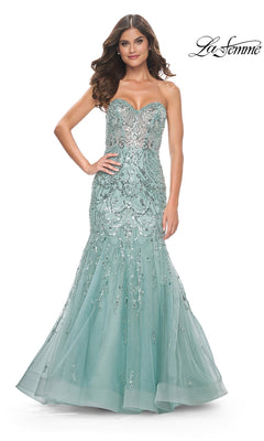 A woman poses with one hand on her hip in the La Femme Strapless Long Mermaid Prom Dress 32053, featuring a fitted light blue bodice, silver sequin embellishments, and a flowing tulle mermaid skirt for a glamorous look.