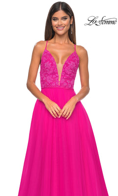 A woman models the La Femme Deep V-Neck Long Tulle Prom Gown 32059 in bright pink, featuring a lace bodice and flowing long tulle skirt, standing against a white background.