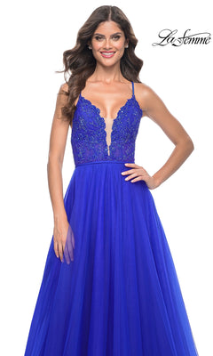 A woman models the La Femme Deep V-Neck Long Tulle Prom Gown 32059 in royal blue, featuring an A-line silhouette, lace bodice, deep V-neck, and long tulle skirt against a white background.