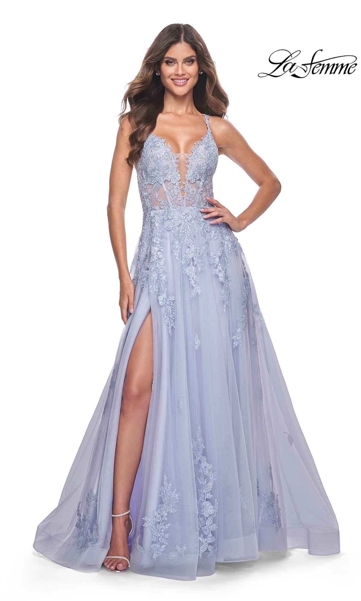 A woman wears the La Femme Embroidered-Lace Long Prom Dress 32062 in light purple, featuring embroidered lace, a deep V-neckline, sheer bodice, and thigh-high slit.