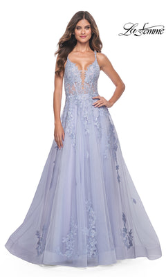 A woman in the La Femme Embroidered-Lace Long Prom Dress 32062, a floor-length lavender gown with thin straps, sheer bodice, embroidered lace details, and a full skirt, stands against a white background.