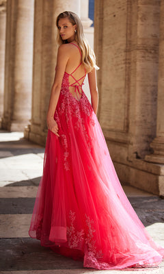 A woman stands outdoors between tall stone columns wearing the La Femme Embroidered-Lace Long Prom Dress 32062, a red gown with floral details and a strappy back.