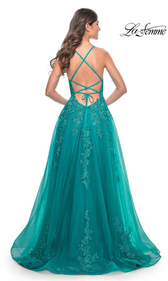 A woman stands facing away, wearing the La Femme Embroidered-Lace Long Prom Dress 32062 in teal with a crisscross open back and lace detailing.